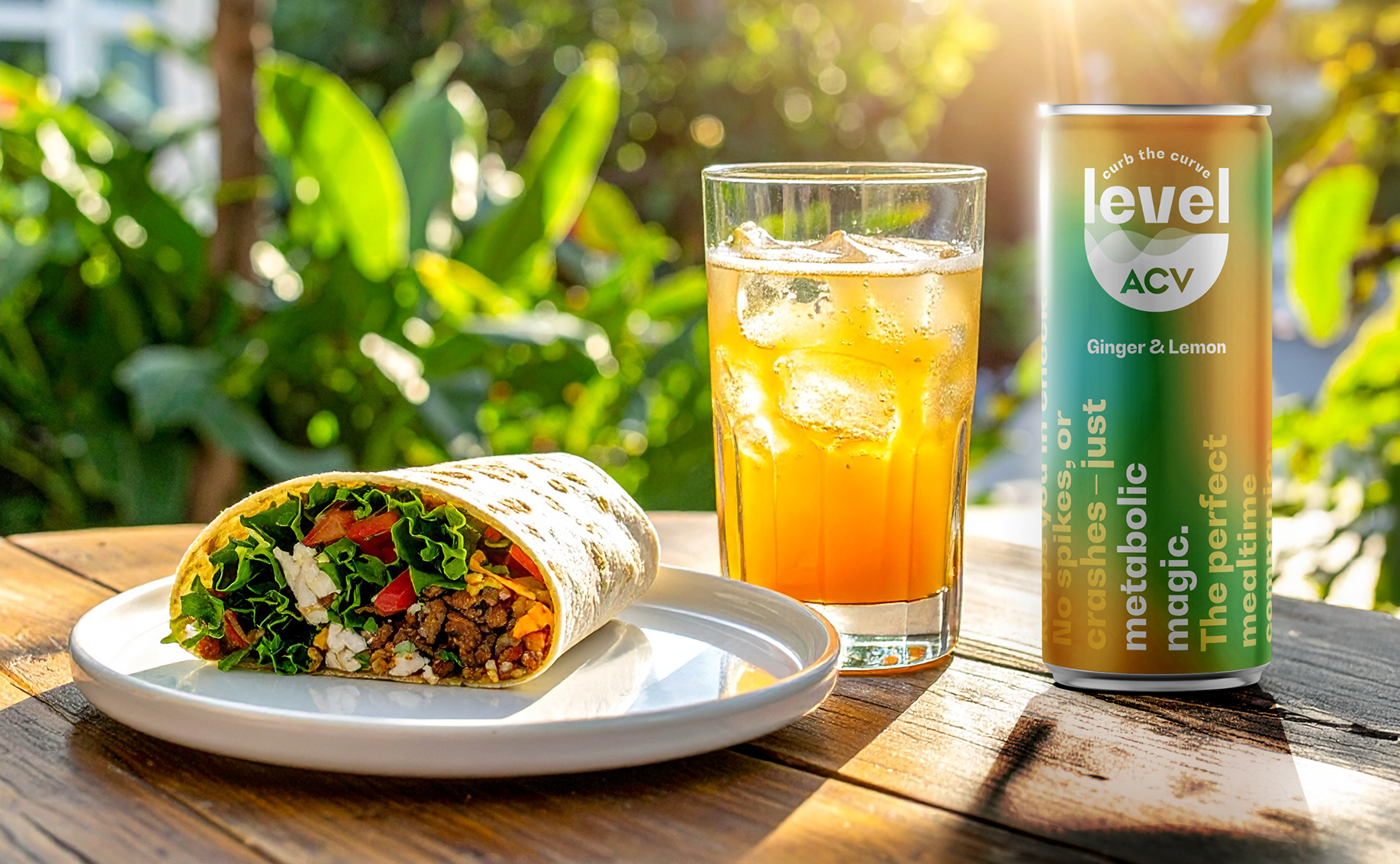 A drink and a salad wrap sit next to a can of Level ACV in a sunny outside setting